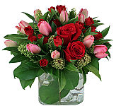 Canada Flowers presents a fresh new arrangement of lush red roses with red and pink tulips in a clear glass cube vase. Featuring same day florist delivered flowers across Canada.