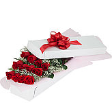 Classic gift of one dozen red roses with baby's breath, arranged in a rose box.