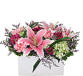 A white ceramic arrangement of stargazer lilies and more. Perfect for Anytime.