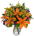 Bold, colourful display of blooms in a modern glass cube vase, featuring orange lilies with purple statice. Flowers delivered same day across Canada.
