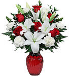 A gorgeous arrangement of red roses with white lilies and white carnations expertly arranged in a red glass vase is perfect for a romantic birthday rendevous. Same day delivery across Canada.