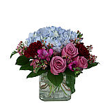 Beautiful handdesigned flower arrangement of roses, hydrangea, freesia, waxflower and carnations.