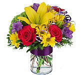 Yellow lilies and daisies, red roses, purple freesia, greenery, curly ribbon, and happy birthday pic all in a clear glass vase.