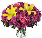 Pink roses, yellow lilies and ample mauve daisies arranged in a clear glass vase. Same day delivery across Canada.