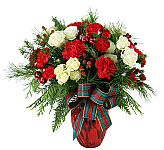 A red holiday vase holds a loveinspired bevy of white spray roses and red miniature carnations with rich seasonal greenery.
