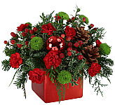 Jingle all the way home! This classic red and green arrangement is the perfect holiday gift! Red ceramic vase with Christmas greens, red mini carnations, green button poms, red berries and pinecones and a shiny red ornament!  