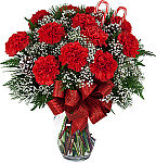 Long lasting red carnations arranged for Christmas with cedar, evergreen, baby's breath, pine cone, ribbon and candy cane.