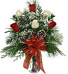 Six red and white long stemmed roses arranged in a clear glass vase with plenty of Christmas greens, baby's breath and festive trimmings. Romantic Christmas flowers available for same day delivery across Canada.