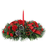 Our original Joy to the World Centerpiece with a hurricane lamp, featuring red carnations and miniature carnations, Christmas greenery and trim.