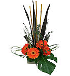 Bamboo, tropical foliage, swirls of bear grass, a burst of orange and a majestic monstera leaf, all combine with exotic flair and zenlike fluidity.