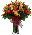 Our finest Fall flower arrangement featuring a variety of yellow and orange roses, orange lilies, red carnations and hypericum berries, ample lush greenery and red organza bow.