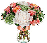 A pretty floral arrangement in a glass vase of peonies, Queen Anne's Lace and spray roses.