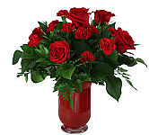 Sometimes flowers speak louder than words…and our elegant red roses and red mini carns speak volumes! Beautifully hand-arranged with lush greenery inside a stunning ruby red vase, each radiant bloom will help you express your love in the most romantic way possible.