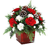 A delightful, affordable flower arrangement of red and white blooms in a modern red glass cube vase with all the Christmas trim.