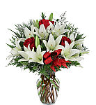 Popular Christmas floral arrangement in a glass vase of white lilies with red roses and limonium. Beautiful. Available for same day delivery across Canada.