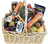 Extravaganza! Large handled wicker basket full of assorted fruits with several delicious snacking treats like peanuts, cheeses, crackers, pickles and more. Friends, family or coworkers will surely gather around.