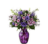 Elegant and chic, this flower bouquet is laced in lavender to send your love, kindness, and gratitude to your recipient this spring season. Lavender roses and purple double lisianthus flaunt their twilight inspired beauty, mingling amongst purple button poms, purple larkspur, pink Limonium, and lush greens, presented in a purple swirled glass vase. The perfect thank you, birthday, or Mother's Day gift.