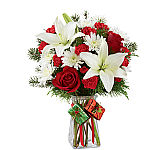 FTD® Christmas floral gift of red roses, red carnations, white lilies and white chrysanthemums in a clear glass vase.