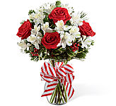 The FTD® Holiday Enchantment Bouquet is a pretty display of red roses, red hypericum berries, white alstroemera, assorted seasonal greens and holly, with a large candycane inspired bow.