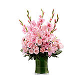 All pink flowers are arranged in a leaf lined glass vase to express sympathy during a time of loss. Suitable for the funeral home or mortuary.