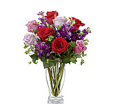 Romantic bouquet of mixed red, lavender and pink roses combined with purple stock and bupleurum.