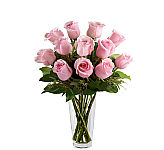 One dozen premium long stemmed red, hot pink, orange and yellow roses are arranged in a clear glass vase with seeded eucalyptus.