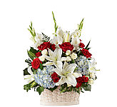 Red and white roses, white gladioli and Oriental lilies, and blue hydrangeas beautifully arranged in a simply lovely white woodchip basket.
