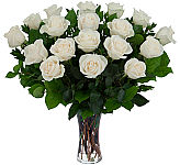 Beautiful funeral tribute of eighteen white  roses arranged in a clear glass vase with added foliage.