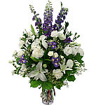Popular sympathy flowers featuring white lilies, carnations and roses with purple irises, delphinium and statice. Same day flower delivery in Canada.