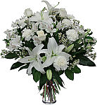 A clear glass vase is arranged with beautiful white flowers for the funeral home or memorial service. A welcome sympathy gift.
