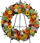 Celebrate their life with an uplifiting, multicoloured funeral wreath in yellow, orange, green, white and mauve.