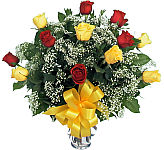 Exceptional colour combination of six red and six yellow long stemmed roses, arranged in a glass vase.
