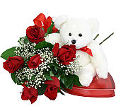 Six premium red long stemmed roses with baby's breath, greens and matching bow, presented with a box of delicious chocolates and a cuddly white plush bear.