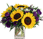 A mesh of bright and subdued hues featuring sunflowers and lisianthus.