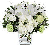Delicate cube vase of white lilies, hydrangea, carnations, roses, and more for sympathy.