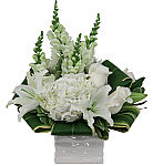 All white flowers are arranged in a white vase, featuring roses, lilies, hydrangea and snapdragons.