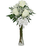 Three white roses in a slender glass vase with baby's breath, greens and matching white bow.