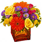 Teleflora's Another Year Bolder brilliant orange vase with bright flowers.