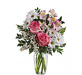 Teleflora's What a Treat bouquet in a glass vase. Pink roses, pink alstroemeria, white daisy mums, statice and assorted greenery.