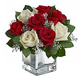 The Faith Hill Snowy Night Bouquet is a gorgeous Christmas arrangement of red and white roses in a silverly glass vase with silver snowflake accents.
