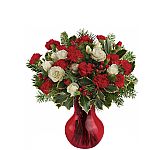 An affordable bouquet of red miniature carnations and red berries with white spray roses, seasonal greenery and variegated holly. Available across Canada.