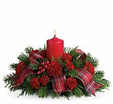 Celebrate a traditional family Christmas with this wonderful holiday centerpiece. Red carnations, fragrant evergreens and shiny ornament balls surround a red pillar candle, and a fancy ribbon adds a special touch! A lovely way to light the holiday table or a pretty sideboard decoration.
