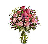 Clear Glass arrangement to include pink spray roses, pink tulips, pink mini carnations, wax flower, pitt and greens.