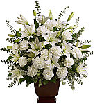 White roses, liles and carnations are arranged in a classic urn container. Same day funeral flower delivery across Canada with Canada Flowers.