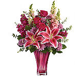 TEV52-1C ​Hot pink roses, pink stargazer lilies, burgundy stock, lavender cushion spray chrysanthemums, pink snapdragons, spiral eucalyptus, and lemon leaf. Delivered in a Bold Elegance vase.