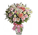 Pretty pink roses, spray roses and miniature carnations, white button spray chrysanthemums, lavender limonium and green pittosporum fill a spring glass vase that's wrapped with a pink satin ribbon. It's confection perfection!