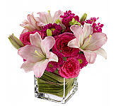A stellar floral arrangement of hot pink roses with pale pink lilies and mixed blossoms arranged in a sparkling, modern glass cube vase. Modern and Trendy bouquets delivered across Canada.
