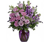 This dramatic arrangement includes lavender roses, lavender stock, lavender cushion spray chrysanthemums, lavender limonium, oregonia and lemon leaf. Delivered in a purple glass vase.